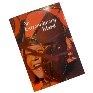 a photograph of the front cover of a book, there is a closeup photo of a young person's face, wearing a red and gold carnival headdress. The title reads 'An Extraordinary Island'